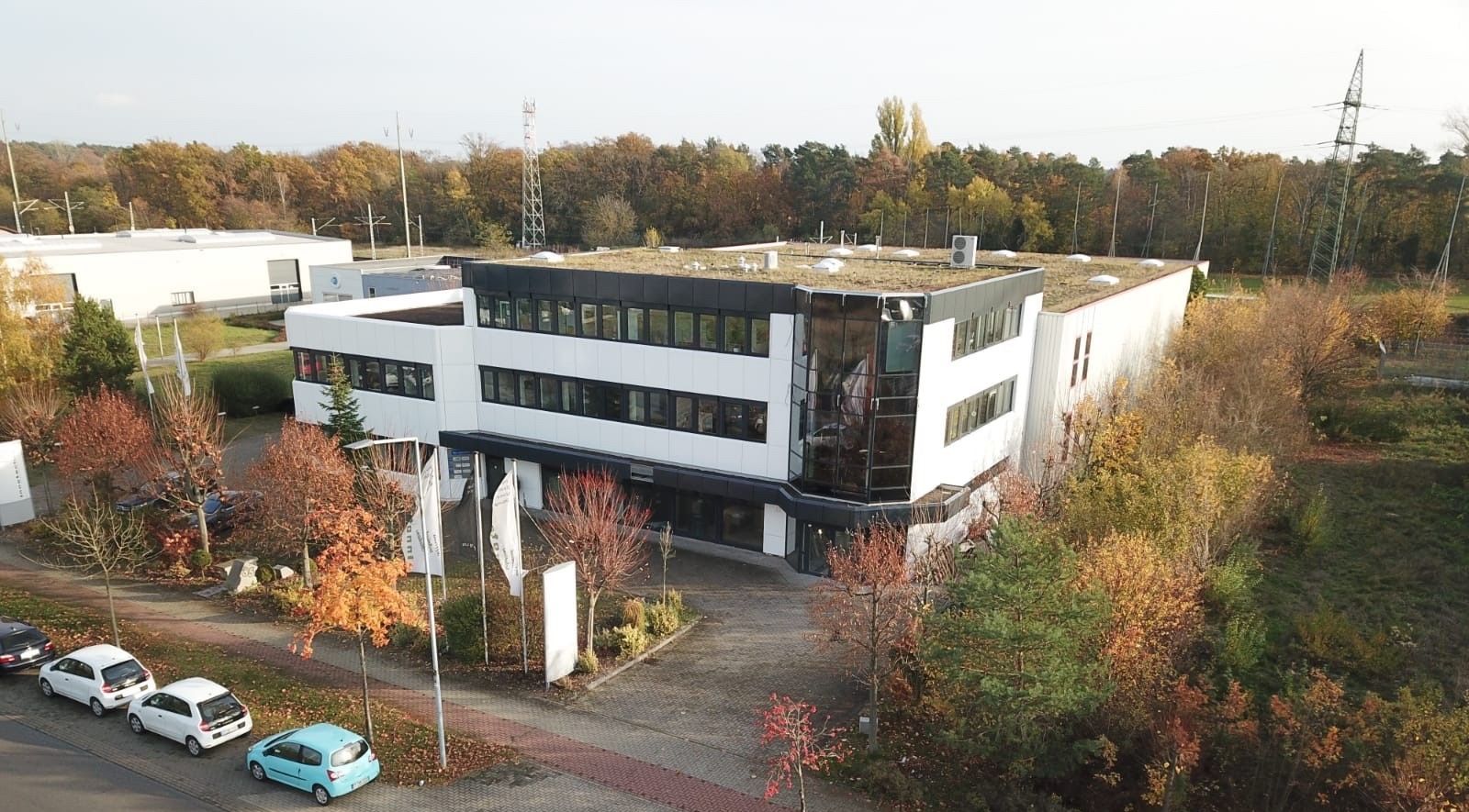 Eine Luftaufnahme des Büros der Firma Innotech Versorgungstechnik GmbH mit vielen Fenstern und mit davor geparkten Autos.